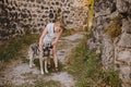 Happy smiling senior elderly mature woman tourist walking outdoors in ancient fortress in Europe hugging homeless big Royalty Free Stock Photo