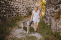 Happy smiling senior elderly mature woman tourist walking outdoors in ancient fortress in Europe hugging homeless big Royalty Free Stock Photo