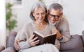 Happy smiling senior family couple in love reading book together at home Royalty Free Stock Photo