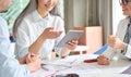 Senior businesswoman holding tablet device with colleagues in office at desk. Royalty Free Stock Photo