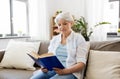 Happy smiling senior woman reading book at home Royalty Free Stock Photo