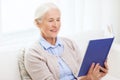 Happy smiling senior woman reading book at home Royalty Free Stock Photo