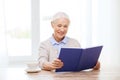 Happy smiling senior woman reading book at home Royalty Free Stock Photo