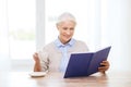 Happy smiling senior woman reading book at home Royalty Free Stock Photo