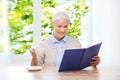 Happy smiling senior woman reading book at home Royalty Free Stock Photo