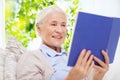 Happy smiling senior woman reading book at home Royalty Free Stock Photo