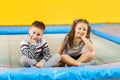 Happy smiling small kids sitting on indoor trampoline and playing in entertainment center Royalty Free Stock Photo