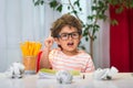 Happy smiling small school boy in glasses with finger up. Back to school. Preschool boy in kindergarten. Kid is drawing Royalty Free Stock Photo