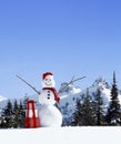 Happy, smiling snowman with Santa hat, Christmas gifts and snowy mountains in background Royalty Free Stock Photo