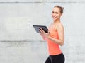 Happy smiling sportive young woman with tablet pc