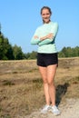 Happy smiling sporty woman after workout outdoors in nature on a sunny day Royalty Free Stock Photo