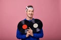 Happy smiling stylish guy in bandana holds two black vinyl records in his hands Royalty Free Stock Photo