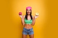 Happy smiling stylish woman with donutes isolated on yellow background