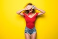 Happy smiling stylish woman with donutes on yellow background