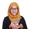 Happy smiling sucessful Asian muslim woman showing mini shopping trolley on her hand Royalty Free Stock Photo