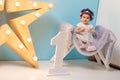 Happy smiling sweet baby girl sitting on armchair with shining light star, Birthday girl, One year old Royalty Free Stock Photo