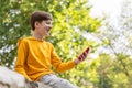 Happy smiling teen boy talking on video call using phone outside. Royalty Free Stock Photo