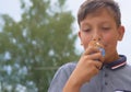 Happy smiling teenage boy eating big ice cream in waffles cone happy laughing on nature background Royalty Free Stock Photo