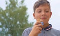 Happy smiling teenage boy eating big ice cream in waffles cone happy laughing on nature background Royalty Free Stock Photo