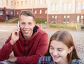 Happy smiling teenage boy talking on his phone against a group of students on the stairs near university Royalty Free Stock Photo