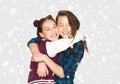 Happy smiling teenage girls hugging over snow Royalty Free Stock Photo