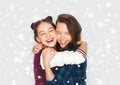 Happy smiling teenage girls hugging over snow Royalty Free Stock Photo
