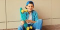 Happy smiling teenager boy with skateboard in casual on city street Royalty Free Stock Photo