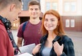 Happy smiling teenager girl with freckles with group of students on background Royalty Free Stock Photo