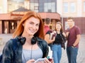 Happy smiling teenager girl with freckles with group of students on background Royalty Free Stock Photo