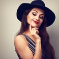 Happy smiling thinking makeup female in black elegant hat looking down on blue background. Closeup vintage bright portrait Royalty Free Stock Photo