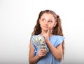 Happy smiling thinking rich kid girl holding money the hand and Royalty Free Stock Photo