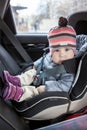 Happy and smiling toddler sitting in child safety seat on back of the car Royalty Free Stock Photo