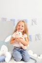 Happy smiling toothless little blonde girl. Child smiling withouth his milk teeth in children room. Sweet little redhead girl is h Royalty Free Stock Photo