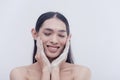 A happy and smiling transwoman washes and exfoliates her face with a foamy facial scrub after a stressful day. Royalty Free Stock Photo