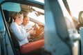 Happy smiling two young adulds couple using smartphone navigation inside car during auto jorney.They are laughing during road trip Royalty Free Stock Photo