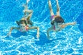 Happy smiling underwater children in swimming pool