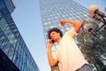 Happy smiling urban hipster young man using smart phone. African american teenager holding mobile smartphone on sunset Royalty Free Stock Photo