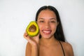 A happy and smiling woman with an avocado. Veganism and vegetarianism