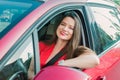 Happy smiling woman in a car. Driving. Portrait of young caucasian business lady in red clothes looking at camera while sitting Royalty Free Stock Photo