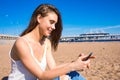 Cheerful female watching video on cell telephone, resting on seashore Royalty Free Stock Photo