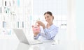 Happy smiling woman at the computer with cash and piggy bank, bu Royalty Free Stock Photo