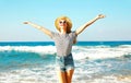 Happy smiling woman enjoys the fresh smell of the sea on a summer day