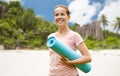 Happy smiling woman with exercise mat over beach Royalty Free Stock Photo