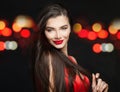 Happy smiling woman fashion model in black carnival mask, long hair and red lips makeup on black background with bokeh sparkle