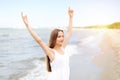 Happy smiling woman in free happiness bliss on ocean beach standing with raising hands. Portrait of a multicultural