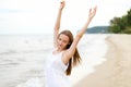 Happy smiling woman in free happiness bliss on ocean beach standing with raising hands. Portrait of a multicultural