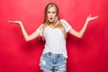 Happy smiling woman gesturing with hands and showing balance isolated on red background Royalty Free Stock Photo