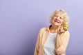 Happy smiling woman in her sixties holding green apple and smiling at camera. Royalty Free Stock Photo