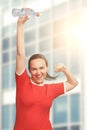 Happy smiling woman holding bottle in hand over her head. Winner Royalty Free Stock Photo
