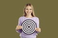 Happy smiling woman holding shooting target to illustrate concept of setting business goal